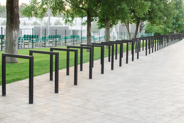 Empty bicycle parking racks in park. Metal construction for Parking of bicycles, scooters, environmental transport in the city. Eco-friendly and sports transport in the city.