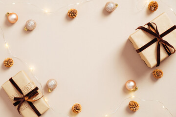 Glamour Christmas composition. Gift boxes, balls and garland on pastel beige background. Flat lay, top view. Minimal, fashion style.