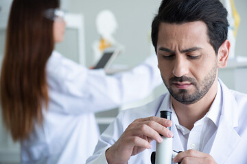 Young scientist looking through a microscope in a laboratory. Young scientist doing some research.