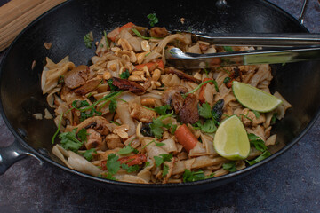Vegan pad thai made with tofu, seitan, mushrooms and carrot served in wok, copy space