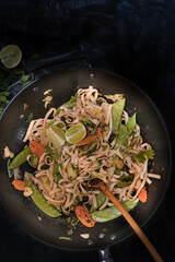 Vegan vegetables pad thai in wok, copy space