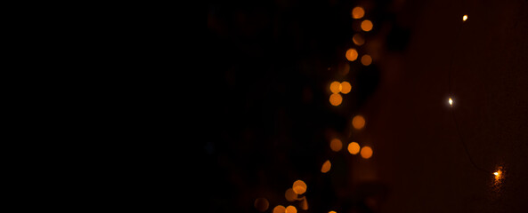festive dark panoramic wallpaper garland light bokeh illumination pattern with empty copy space for your text here on black background Christmas advertising