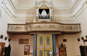 Obraz na płótnie Canvas Antico organo a canne con palco in legno dipinto sull’ abside di una chiesa e portone principale