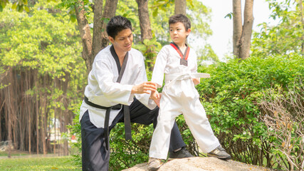 young, beautiful, successful multi ethical kids in karate position with man instructor practicing...