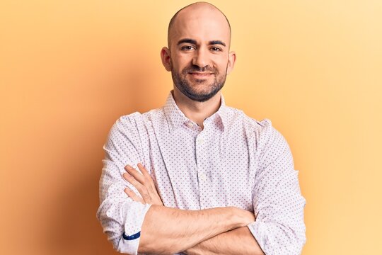 Young handsome bald man wearing elegant shirt happy face smiling with crossed arms looking at the camera. positive person.