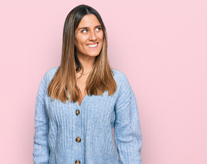 Fototapeta premium Young woman wearing casual clothes looking away to side with smile on face, natural expression. laughing confident.