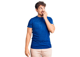 Young handsome man with curly hair wearing casual clothes looking stressed and nervous with hands...