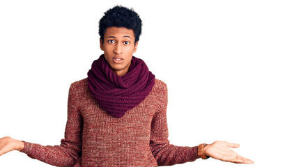 Young african american man wearing casual winter sweater and scarf clueless and confused with open...