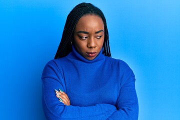 Young african american woman wearing casual winter sweater skeptic and nervous, disapproving expression on face with crossed arms. negative person.