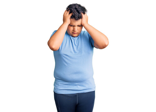 Little boy kid wearing sports workout clothes suffering from headache desperate and stressed because pain and migraine. hands on head.
