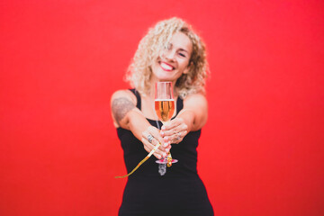 portrait beautiful curly woman celebrating new year 2021 smiling and looking at the camera holding a glass or cup with champagne