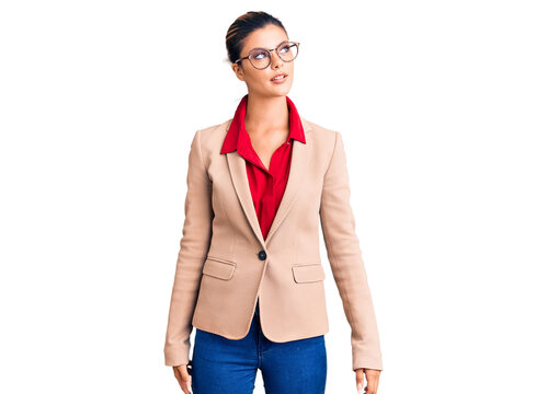 Young beautiful woman wearing business shirt and glasses smiling looking to the side and staring away thinking.