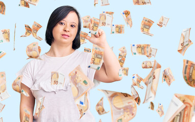 Brunette woman with down syndrome wearing casual white tshirt showing and pointing up with fingers...