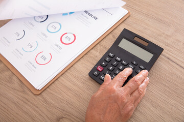 One hand using calculator and financial materials