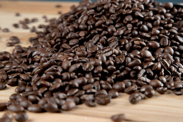 Café negro en grano sobre madera y en un recipiente de cristal 