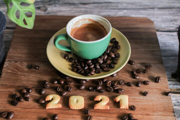 2021 bread number and  coffee cup on wooden table with coffee beans.Happy new year 2021, Holidays food art concept. (close up)
