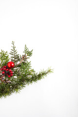  Creative winter layout made with evergreen tree branches and red round Christmas decorations. Flat lay.