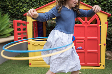 Young girl child holding a hula hoop outdoors playing having fun