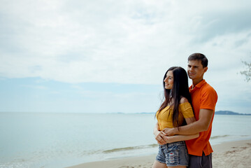 Couple young man and woman dating looking sea on the beach