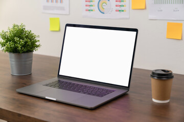 Laptop with blank screen on table in modern office. Mockup of advertisement.