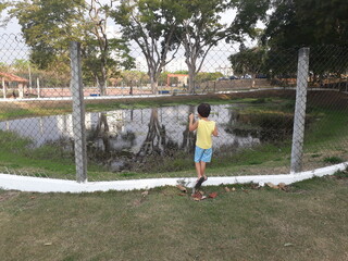 child on a fence with lake