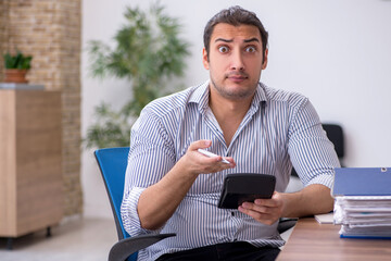 Young male bookkeeper working in the office