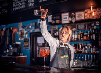 Girl bartender concocts a cocktail on the beerhall