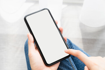 Woman hand holding smartphone and the screen is blank, social network concept, copy space for your advertising.