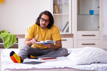 Young male student preparing for exams at home