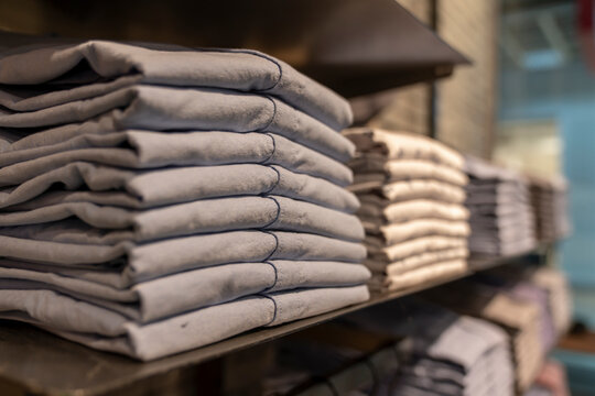 stacks of clothing close-up, men's trousers in calm colors, blurr soft focus