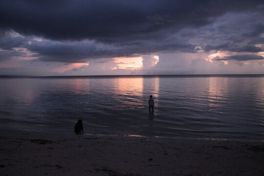 Children playing at the beach on sunset after the storm.