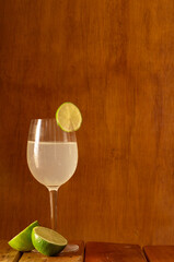 Copa de zumo de limón con fondo de madera y una rodaja de limón de adorno