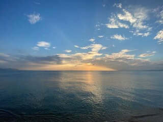 Orange Sunset at dawn with the wide view of sea and small boat floating on the ocean