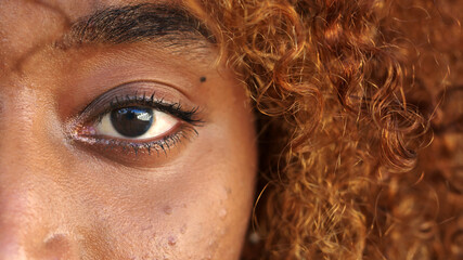 Close up, eye of an african american young woman looking at the camera. High quality photo
