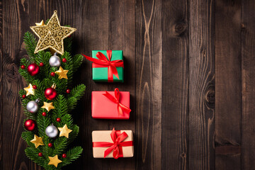 Beautiful Christmas green tree fresh fir branches and ornaments gift box and the star in-studio shot on black wooden background with copy space, New year card concept