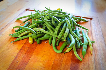 Fresh green beans in the middle of a cutting board