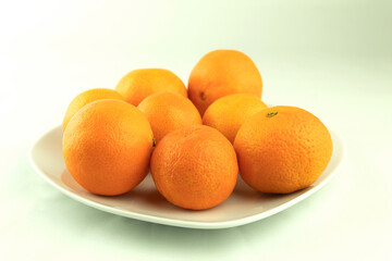 Fresh tangerines in a plate on a white background