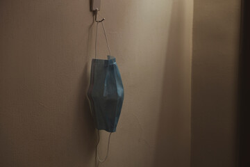 Medical face mask hanging on concrete wall. Corona virus and healthcare concept. 