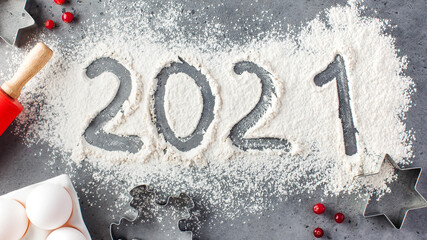 The number 2021 is drawn on flour. The concept of eve 2021, making Christmas cookies.