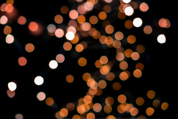 Blurred abstract gold glitter texture, defocused christmas lights on black background. Holiday christmas concept.