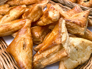 Several triangular puff pastry on a wicker basket
