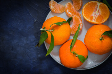 Tangerines on a bright plate and a blue background.