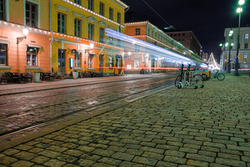 Fototapeta na wymiar Helsinki, Finland November 22, 2020 Senate Square. Blurred public transport traffic, tram in the city center at night. Long exposure.