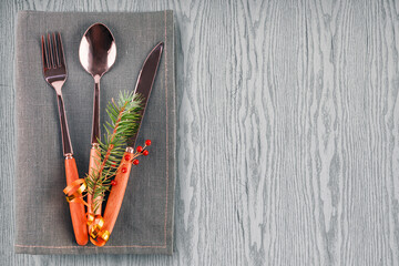 Fork, spoon, knife on a gray napkin on a gray wooden background. Serving a festive table with a...