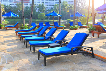 Resort swimming pool with empty a lounge chairs in the morning.