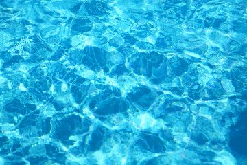 Fototapeta na wymiar Blue swimming pool water reflecting movement with sun rippled