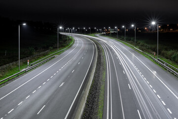 Fototapeta na wymiar Autostrada nocą z latarniami i samochodami