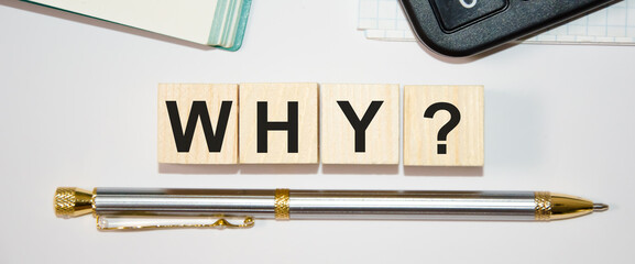 text why is written on wooden cubes that lie on a white background on top of a notebook and a...