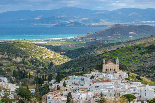 panorama view of traditional architecture with whitewashed houses and the cristian church of Agia Triada in the traditional village  lefkes in Paros island, Greece and naxos island as background