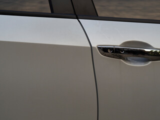 Silver brond car doors with mirrors reflected against the clouds of the sky